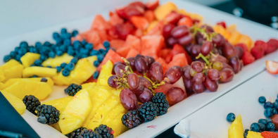 Plate of fruit including raspberries, blueberries, grapes, watermelon, pineapple, blackberries, and strawberries